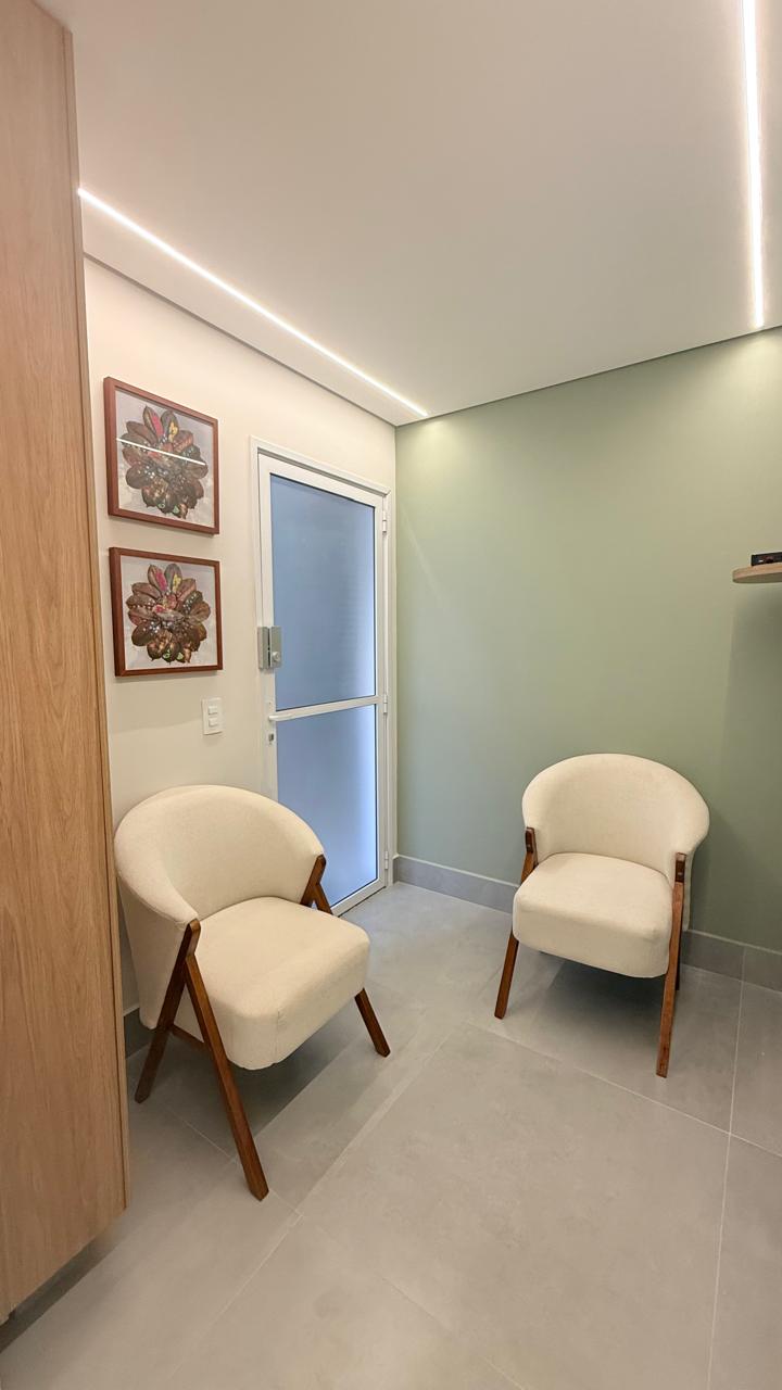 Sala de espera com duas poltronas claras